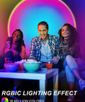 Sunset Projection Lamp With 64 Color Options, App Controlled Ambient Light With Ivy Leaves For Bedrooms And Parties, Indoor Vibe Setter, Projector Lamp For Cozy Movie Nights And Birthday Celebrations illuminating a room with people
