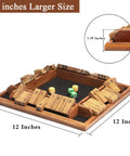 12 inch Shut The Box Dice Game on a solid wood tabletop, showing black felt surface and multi-colored dice, for 1 to 4 players