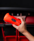 Hand holding a red Stiff Bristle Carpet And Upholstery Scrub Brush For Auto And Home Use, Heavy Duty Grime Buster, showing bristles