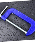 Blue Beefy Heavy Duty 6-Inch G Clamps For Woodworking And Metalworking on wet black surface