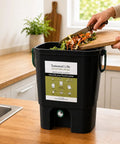 Indoor Bokashi Composting Starter Kit With 2.2 lb Premium Bokashi Bran in black, shown on a kitchen countertop with food scraps.