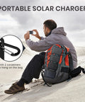 Man using Foldable 36W USB Solar Panel Charger With IP57 Waterproof Outdoor Power Bank on backpack with carabiners in desert