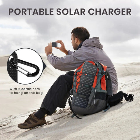Man using Foldable 36W USB Solar Panel Charger With IP57 Waterproof Outdoor Power Bank on backpack with carabiners in desert
