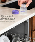 Soft Anti Colic Nipples For Everyday Bottle Feedings Paired With 5 Oz Breastmilk Storage Bottles In A Four Pack being held over a dishwasher.