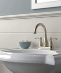 Porter Two Handle Centerset Bathroom Faucet In Brushed Nickel With Mid Arc Spout 7 Inch High, 5 Inch Reach, installed on sink