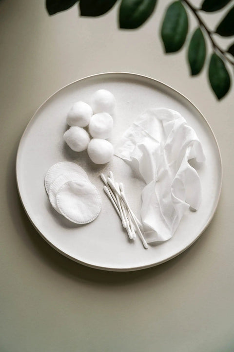 Cotton balls, pads, and swabs on a plate, including 100 Percent Certified Organic Cotton Swabs No Man Made Materials 200 Count