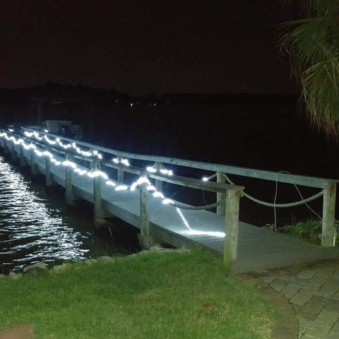50FT 360 LED Waterproof Rope Lights 110V Connectable Indoor Outdoor White LED Rope Lights For Deck Patio Pool Landscape Lighting With Easy Install Screws And Clamps decorating a wooden dock at night.