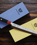 Premium Whetstone Kit With 3000 And 8000 Grit, Extra Large Stones, knife alongside two colored cases on wooden surface