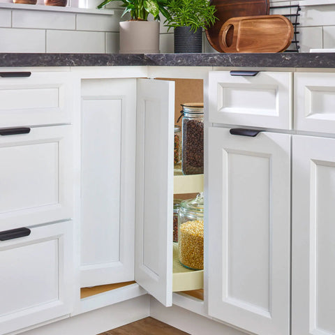 Two-Tier Pie-Cut Lazy Susan Organizer For Base Corner Kitchen Cabinets With Almond Plastic Shelves 28 Inch Wide 18 Inch Deep 26 Inch High Easy Inside-Cabinet Assembly Space Saving Design Smooth 360 Degree Access visible in open cabinet showing shelves with jars.