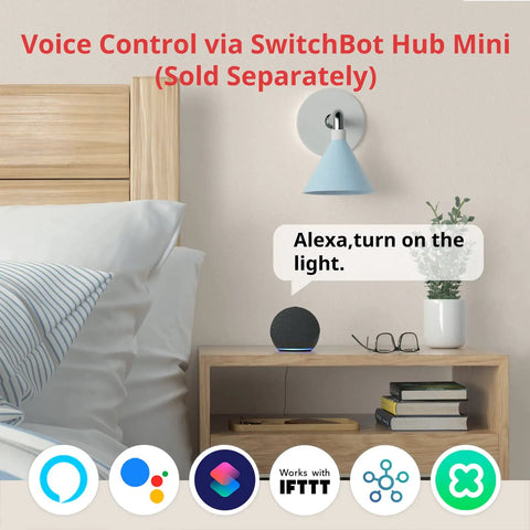 Nightstand with voice-controlled smart button pusher setup next to a bed, showcasing Bluetooth control and optional hub for voice commands.