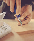 Close-up of blue-handled tool from 12 Pack Linoleum Cutter Kit For Block Printing And Linocut in use with blade set beside