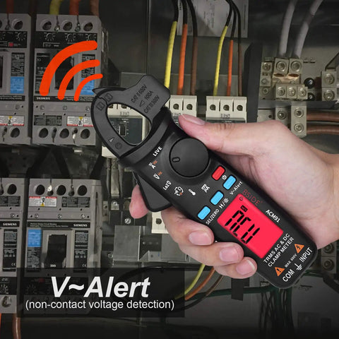 Hand using Pro Grade 1mA Resolution DC Clamp Meter True RMS Digital Multimeter highlighting V-Alert feature in electrical panel.