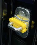 Close-up of a yellow door lock shock absorber pad on a car latch. Door Lock Shock Absorber Pads 4 Pack Red Rubber Noise Dampening Bumpers