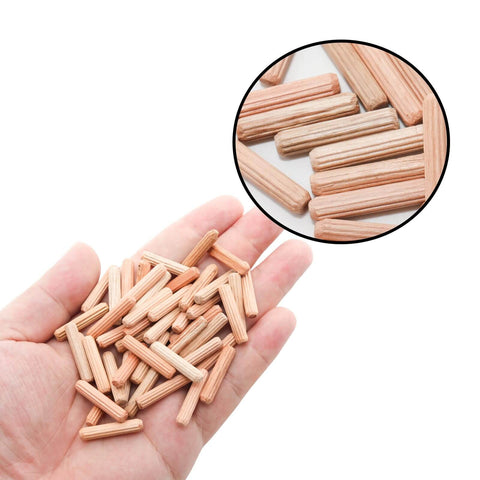 Hand holding 48 Pack 5Mm By 25Mm Wooden Dowel Pins With Fluted Beveled Ends For Shelves And Woodworking Hardwood Dowels For A Tight Friction Fit 0.2 Inch By 1 Inch Durable Wooden Pegs For Quick DIY Furniture Assembly, shown with a close-up inset of dowels on a surface.
