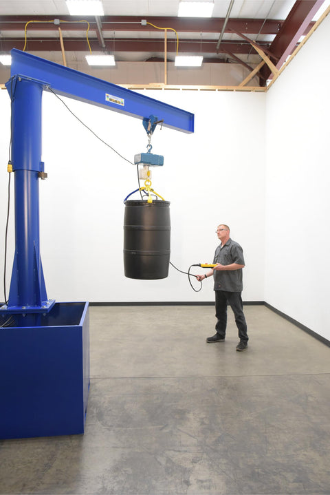 Built Tough Portable Jib Crane With Eight Foot Steel I Beam And 1000 Lb Capacity lifting a black barrel in a workshop.