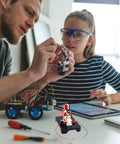 Adults assembling DIY Electric Motor Kit for Hands-On Learning, Simple 3V and 6V DC Motor Model Kit with tools and tablet in science lab