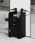 Mobile Salon Station On Wheels For Hair Stylists And Barbers Sleek Black Trolley Cart With Swivel Casters Pro Grade Organizer For Spa Nail And Beauty Tools Easy Move With Ample Storage Drawers in a salon setting, featuring two drawers and tool holders.