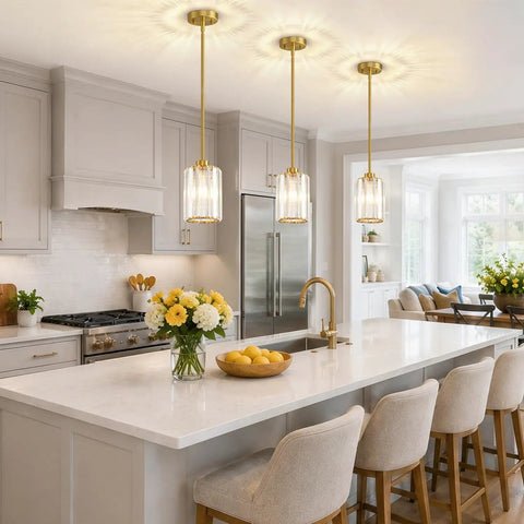 Straight Up Three Pack Brushed Gold Crystal Pendant Lights For Kitchen Islands, elegant mini chandeliers above a kitchen island.