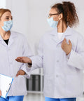 Two professionals wearing white unisex lab coat with 3 pockets for men and women, 3-piece set, clinic ready, discussing.