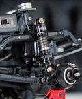 Close-up of 40mm Big Bore Oil Shock Absorber on 1/24 RC rig SCX24 FCX24M, black aluminum and nylon, threaded body visible.