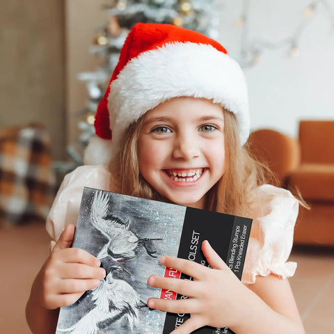 Child in Santa hat holding a 14 Piece White Charcoal Pencil Set For Drawing And Sketching, Pro Grade White Chalk Pencils box.