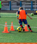 Child practicing soccer with 4 Pack 18 Inch Collapsible Traffic Cones Orange With Reflective Collar For Road Safety Driving Practice And Parking Lot Use Foldable Pop Up Cones High Visibility And Easy Storage In Your Car Or Garage