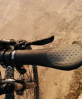 Close-up of ergonomic anatomic handlebar grip with triple density comfort bar end extensions and anti-slip texture on a bike.