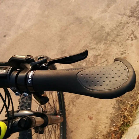 Close-up of ergonomic anatomic handlebar grip with triple density comfort bar end extensions and anti-slip texture on a bike.