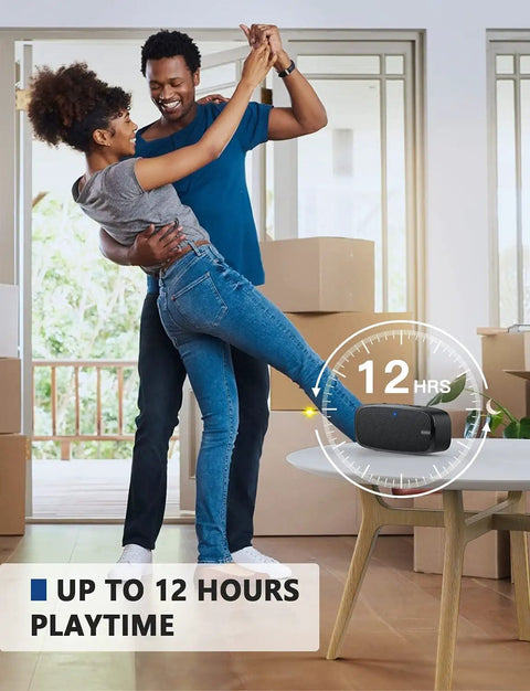 Couple dancing in bright living room with Bluetooth Speaker Portable Wireless Speaker With Loud Stereo Sound And Rich Bass, 12 Hour Playtime on table.
