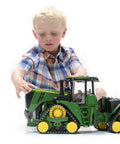 Child playing with John Deere 9620RX Track Belts Tractor Toy Realistic 1 To 16 Scale German Made ABS Plastic Farm Vehicle