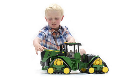 Child playing with John Deere 9620RX Track Belts Tractor Toy Realistic 1 To 16 Scale German Made ABS Plastic Farm Vehicle