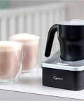 Automatic Milk Frother And Hot Chocolate Maker For Barista Level Foam At Home With 8 Oz Frothing Capacity And 12 Oz Heating Dishwasher Safe Removable Milk Pitcher With Clear Lid Great For Lattes Cappuccinos And Mochas next to two cups of frothed milk