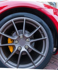 Close-up of alloy wheel on red vehicle with lug nut screws for ATV go kart and outdoor racing no hassle install wheel fasteners