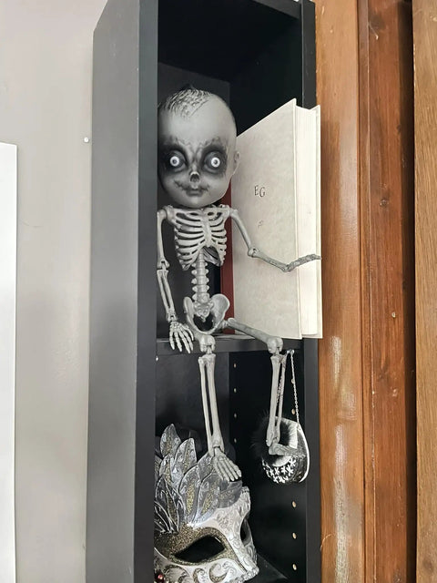 18 Inch Creepy Skeleton Boy Doll With Movable Joints seated on shelf, durable all weather plastic, realistic bone finish, Halloween