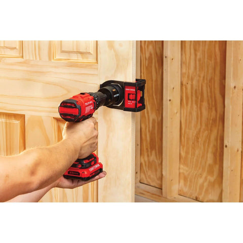 Craftsman Bi-Metal Door Lock Installation Kit mounted on a wooden door frame with a red cordless drill in use