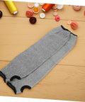 Tough As Nails Cut Resistant Arm Sleeves With Thumb Hole Grip, breathable grey mesh work guards on wooden surface.