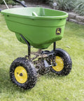 Push Broadcast Spreader With 130 Lb Capacity And Rust Proof Poly Hopper in use spreading material on a lawn
