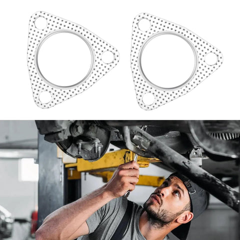 Two 2-inch exhaust flange gaskets with 3-bolt pattern; perforated metal finish; mechanic under car.