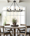 Homestead 25 Inch Six Light Wagon Wheel Chandelier With Gray Oak Wood Finish And Textured Black Accents in dining room setup.