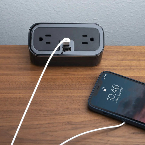 Compact Tabletop Power Strip Charging Station With 2 Tamper Resistant Outlets USB A And USB C Ports Rotated Plug Layout Ideal For Nightstands And Desks shown on a wooden desk.