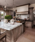 Modern kitchen with marble island, wood cabinetry, and elegant chandeliers.