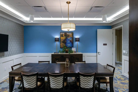 Round LED Downlight That Delivers 1500 Lumens At 3500K Neutral White illuminating a conference room with blue walls.
