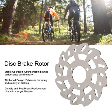 Heavy Duty 140mm Disc Brake Rotor With Innovative Cutout Cooling Tech For Rapid Heat Dissipation Plug And Play Installation For Dead Nuts Stopping Power On Road And Mountain Bikes mounted on a bike in a forest.