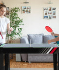 49 Inch 4 In 1 Combo Game Table Featuring Fast Swap Foosball Slide Hockey Ping Pong And Pool Tops Built For Adult Game Rooms Weekend Warrior Sessions And Chill Hangouts during a friendly ping pong match.