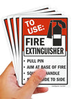 Hand holding 7x5 Inch Fire Extinguisher Instruction Stickers Pack, Pull Pin, Aim at Base, Squeeze Handle, 5 Mil Laminated Polyester With SuperStick Adhesive, Red Black White, Made in USA