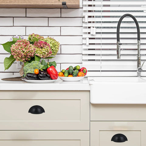 Kitchen display with Set Of 10 Cast Iron Cup Drawer Pulls With Black Coated Finish on beige cabinets beside a white sink.