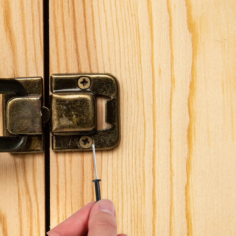 Inserting 50 Pack Black Aluminum Pop Rivets M4x25 Flange Blind Rivets into wooden surface, showing hand and latch detail