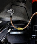 Copper-nickel 3/16 inch brake line with brass fittings installed under a vehicle near suspension.