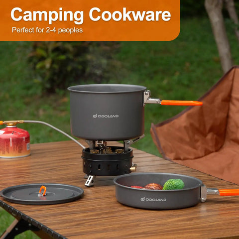Nonstick Camping Cookware Mess Kit with lightweight pot and fry pan on outdoor table, mesh bag included, ideal for backpacking.