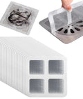 Nukinp Disposable Hair Drain Stickers, 60 Pack 4x4 fiberglass drain covers with hair samples in use above a drain.